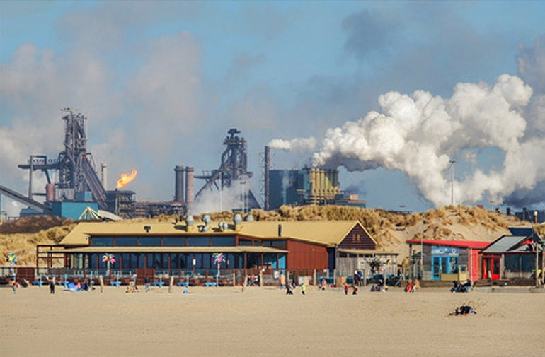 Tata Steel factory polluting the environment on a sunny beach day in Wijk aan Zee. Read the story on Alaia Surf